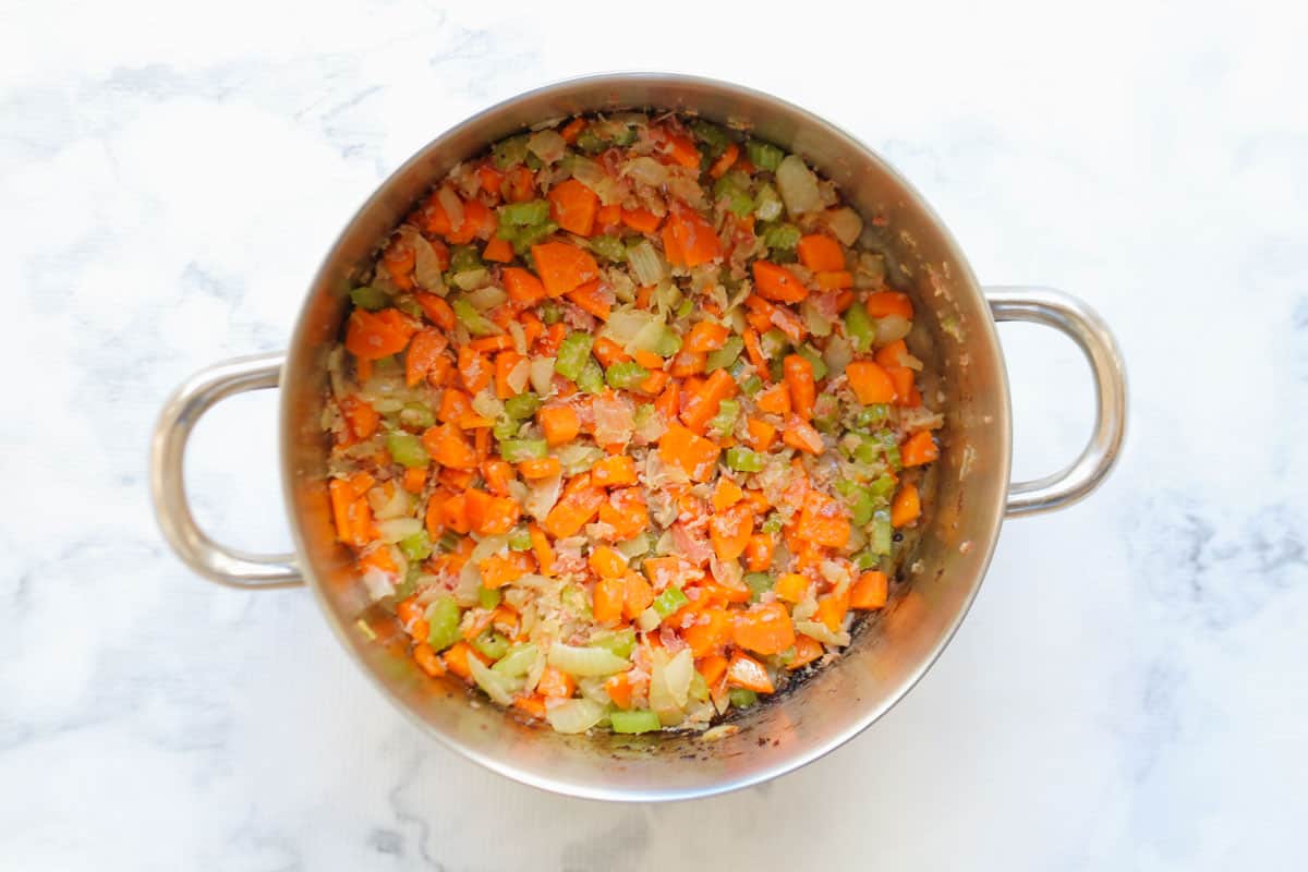 Sauteed vegetables in a large pot.