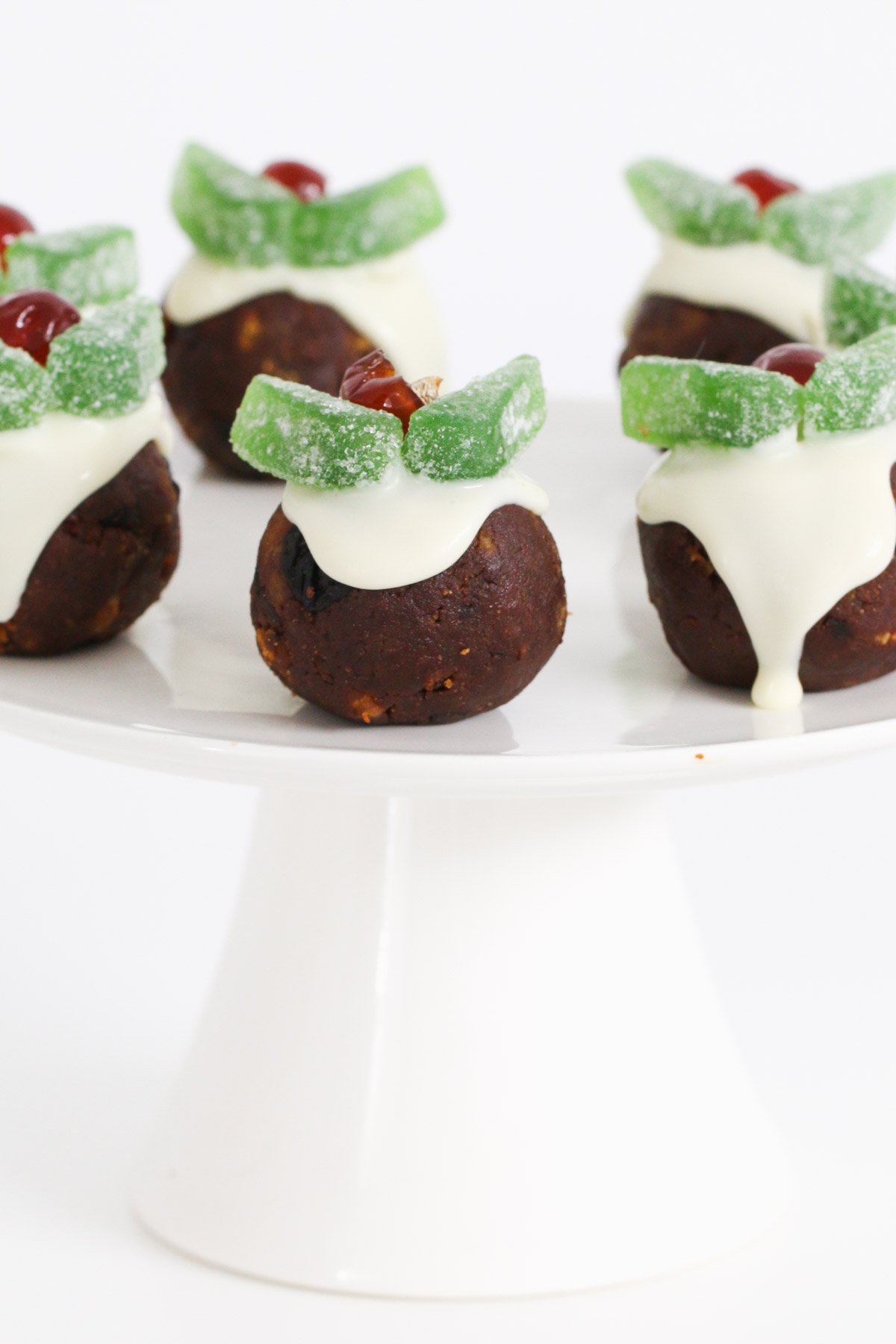 Mini Christmas pudding balls on a white cake stand.