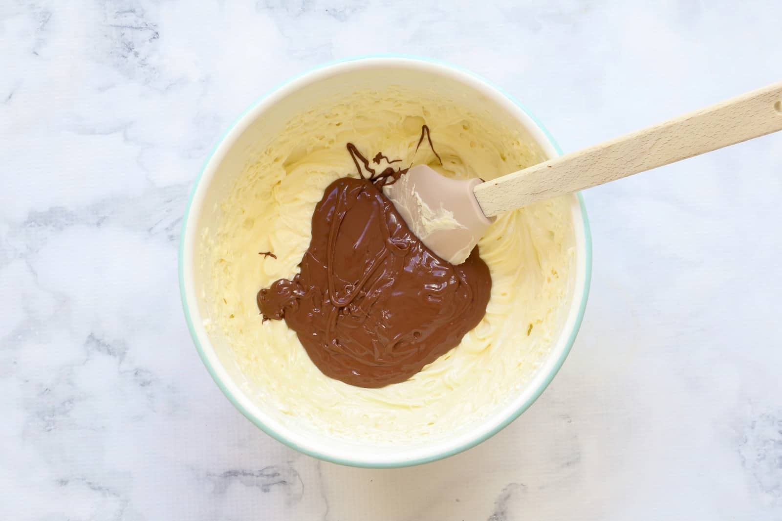 Milk chocolate on top of cream cheese mixture in a bowl.