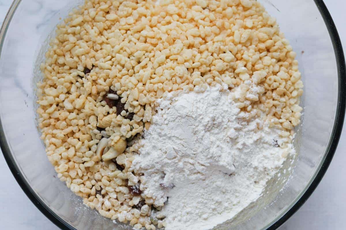 Flour and puffed rice added to other ingredients in a bowl.
