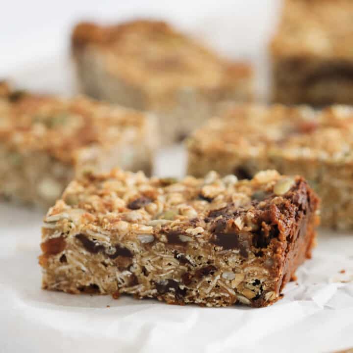 A piece of muesli bar on a white baking paper sheet.