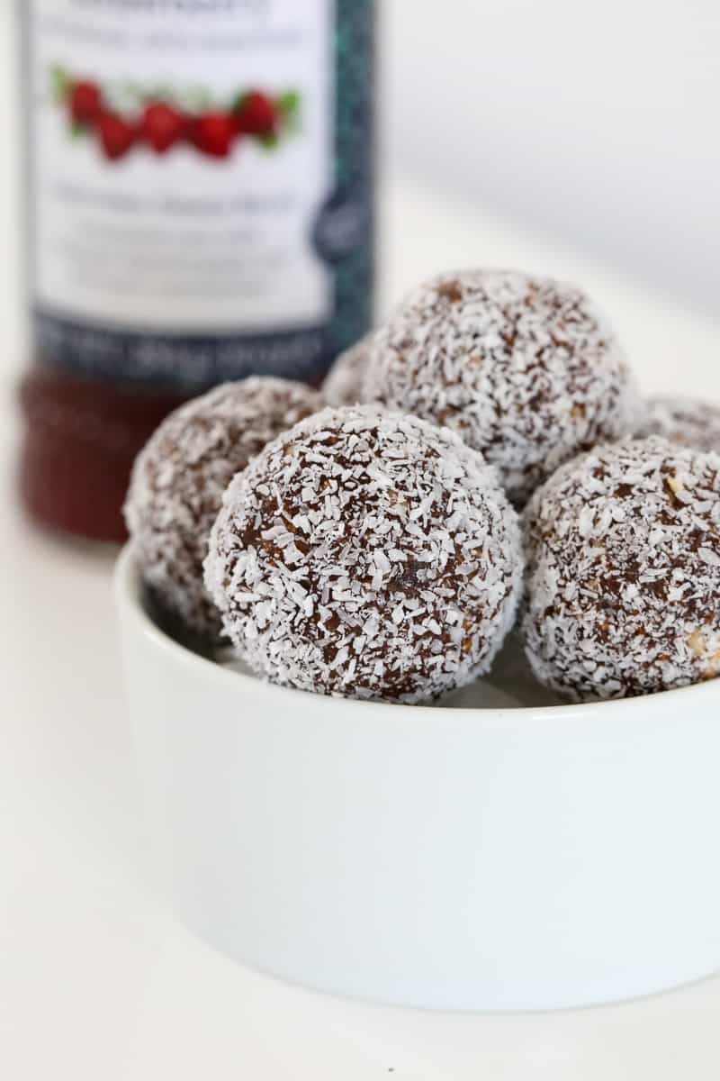 Coconut coated healthy bliss balls in a bowl.