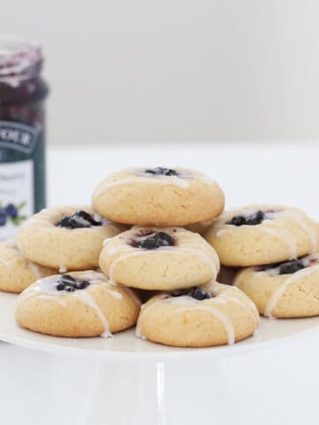 Blueberry and lemon cookies on a white cake stand.