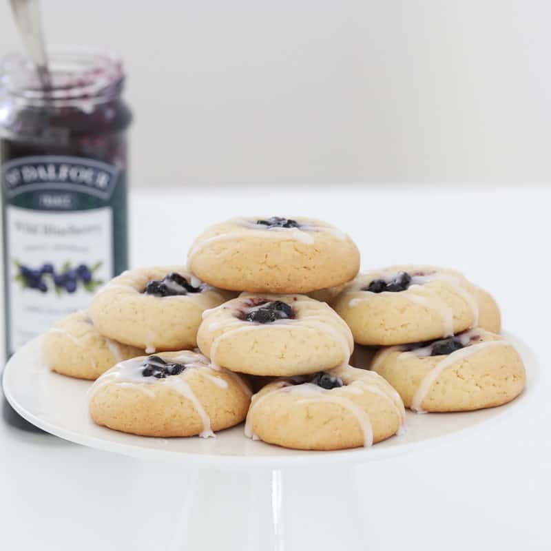 Blueberry and lemon cookies on a white cake stand.