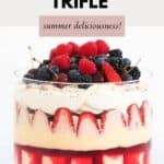A strawberry trifle in a deep glass bowl, to show the layers, decorated with fresh berries.