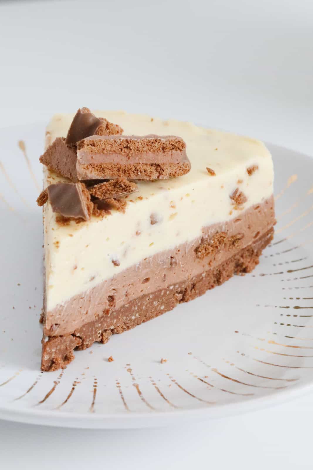 A piece of cheesecake with chopped Tim Tams on top.