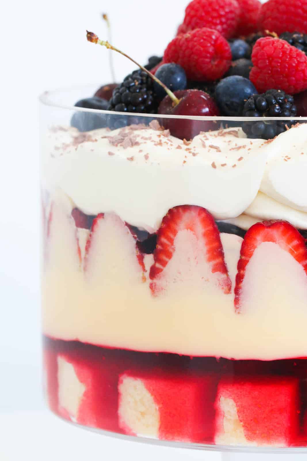 A trifle with berries, custard, cream, jelly and cake.