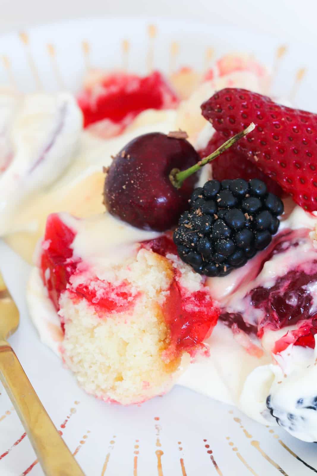 Fresh berries, cream, custard and cake on a plate.