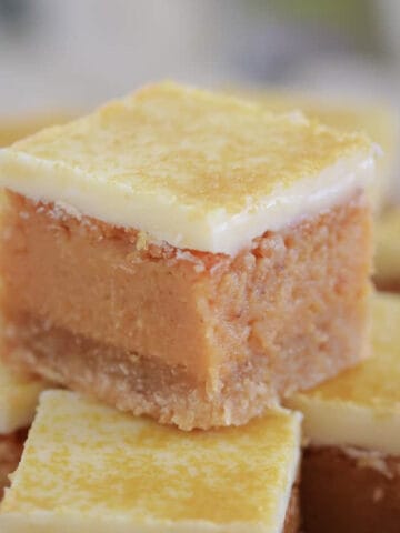 A stack of golden caramel filled squares with white chocolate topping