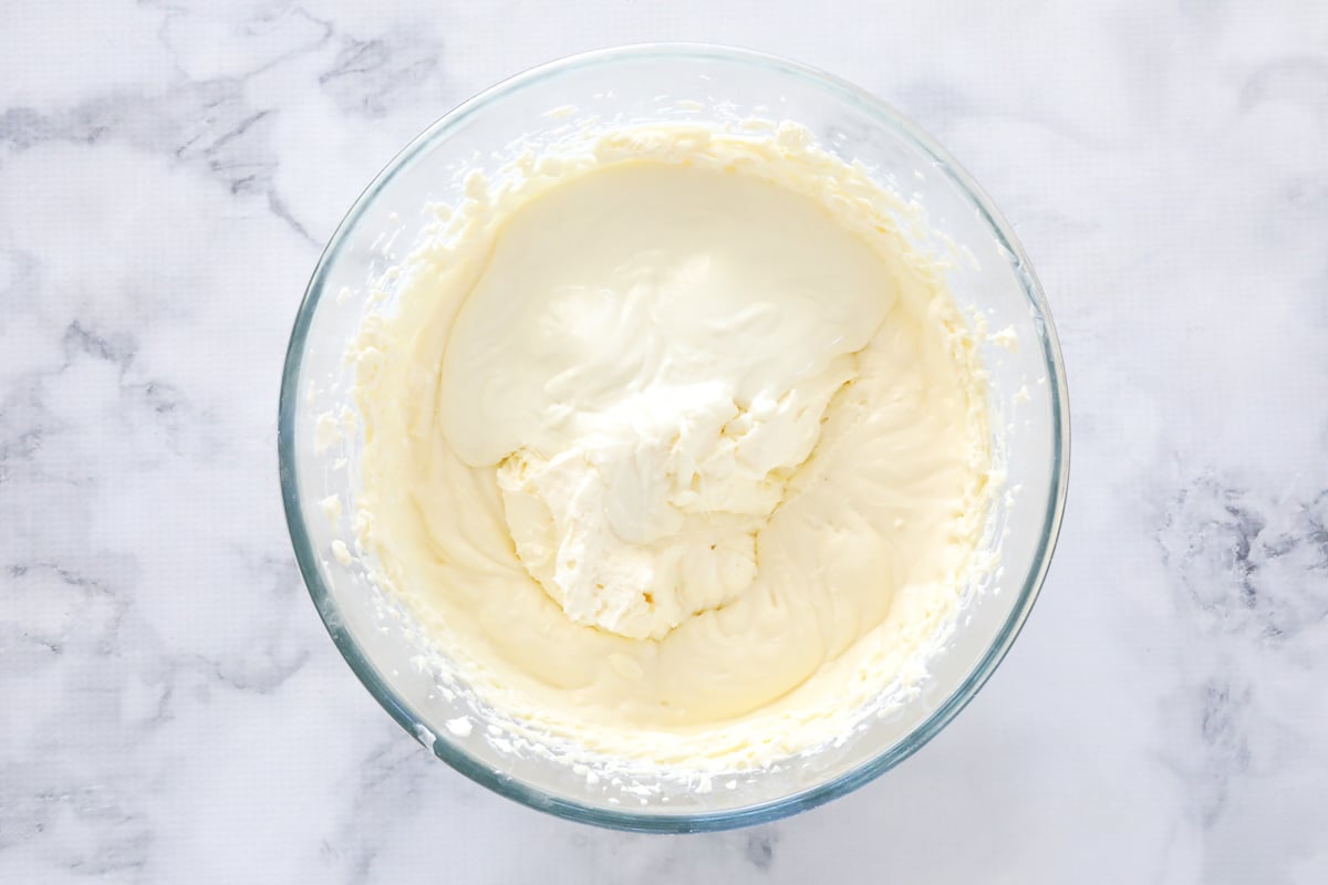 Cream cheese, white chcolate and cream mixture in a bowl.