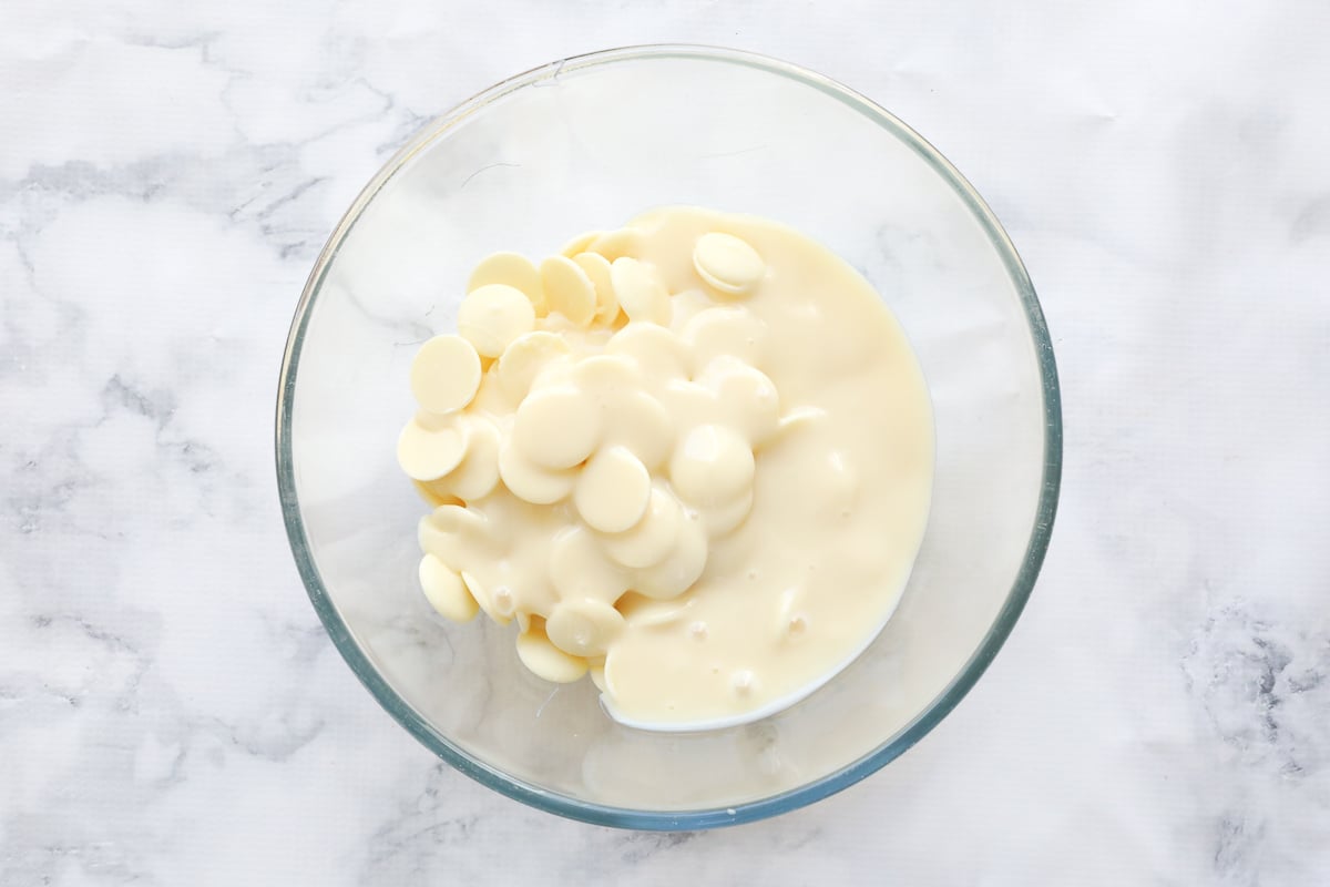 White chocolate melts and sweetened condensed milk in a glass bowl.