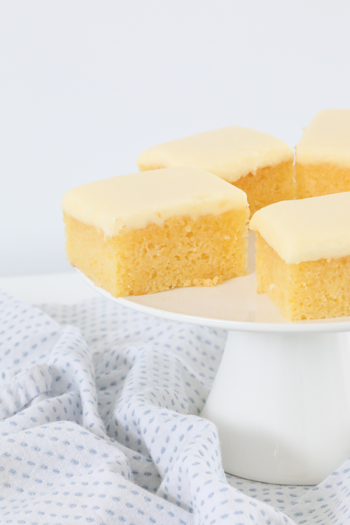 Pieces of a baked lemon slice on a white cake stand