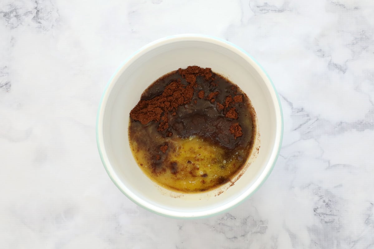 Crushed chocolate biscuits and melted butter in a bowl.