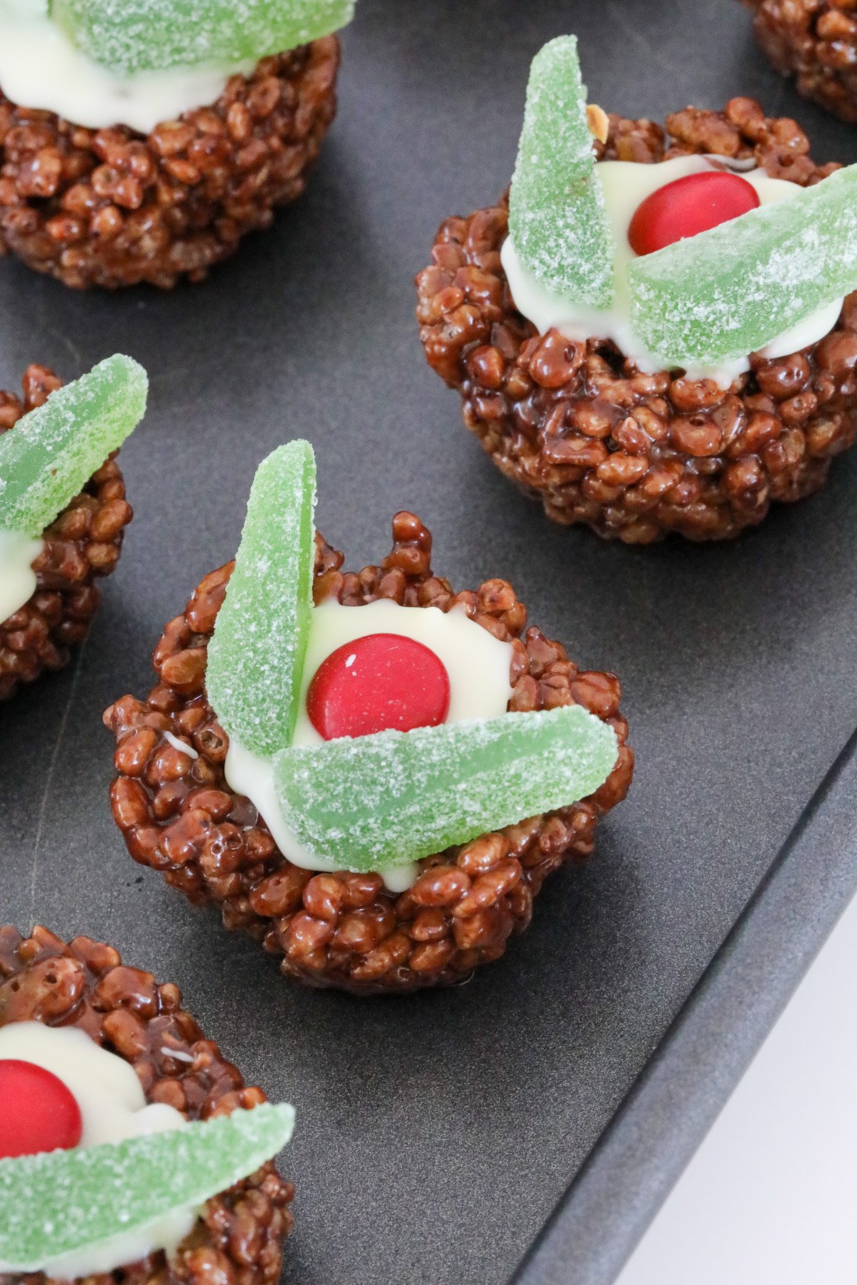 Christmas decorated puddings made with rice bubbles on a tray.