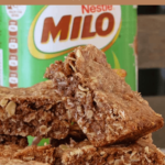 A Pinterest image of an oat slice with a tin of Milo in the background and the text overlay 'oat and milo slice'