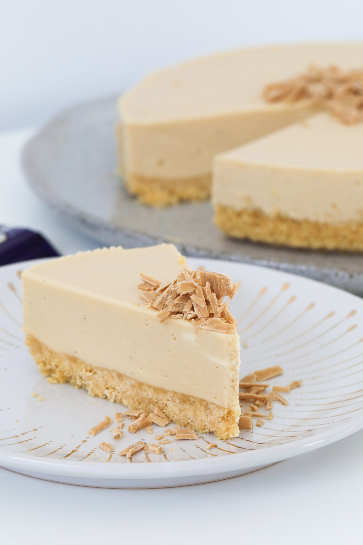 A slice of white chocolate and caramel cheesecake served on a plate.