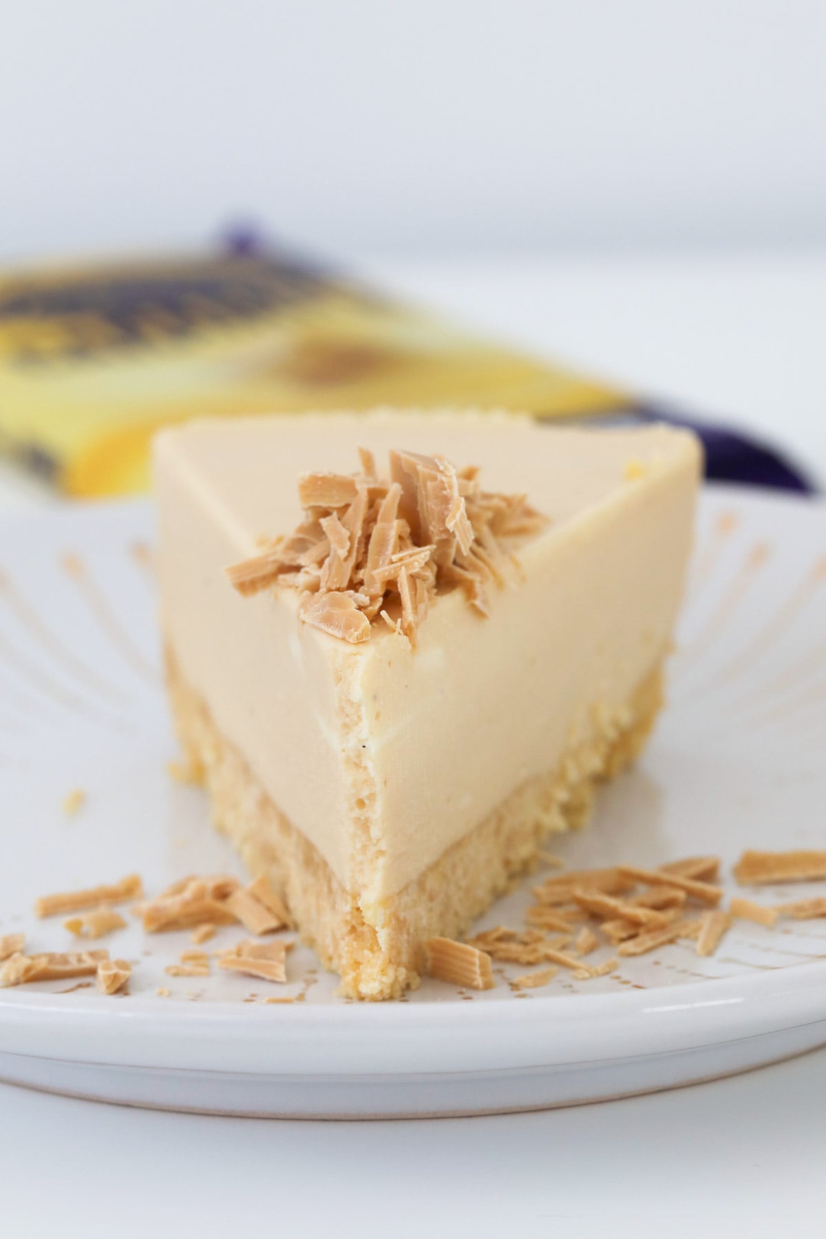 Grated caramel chocolate on top of a slice of cheesecake.