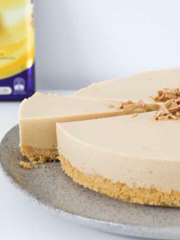 A slice being removed from a caramel cheesecake.