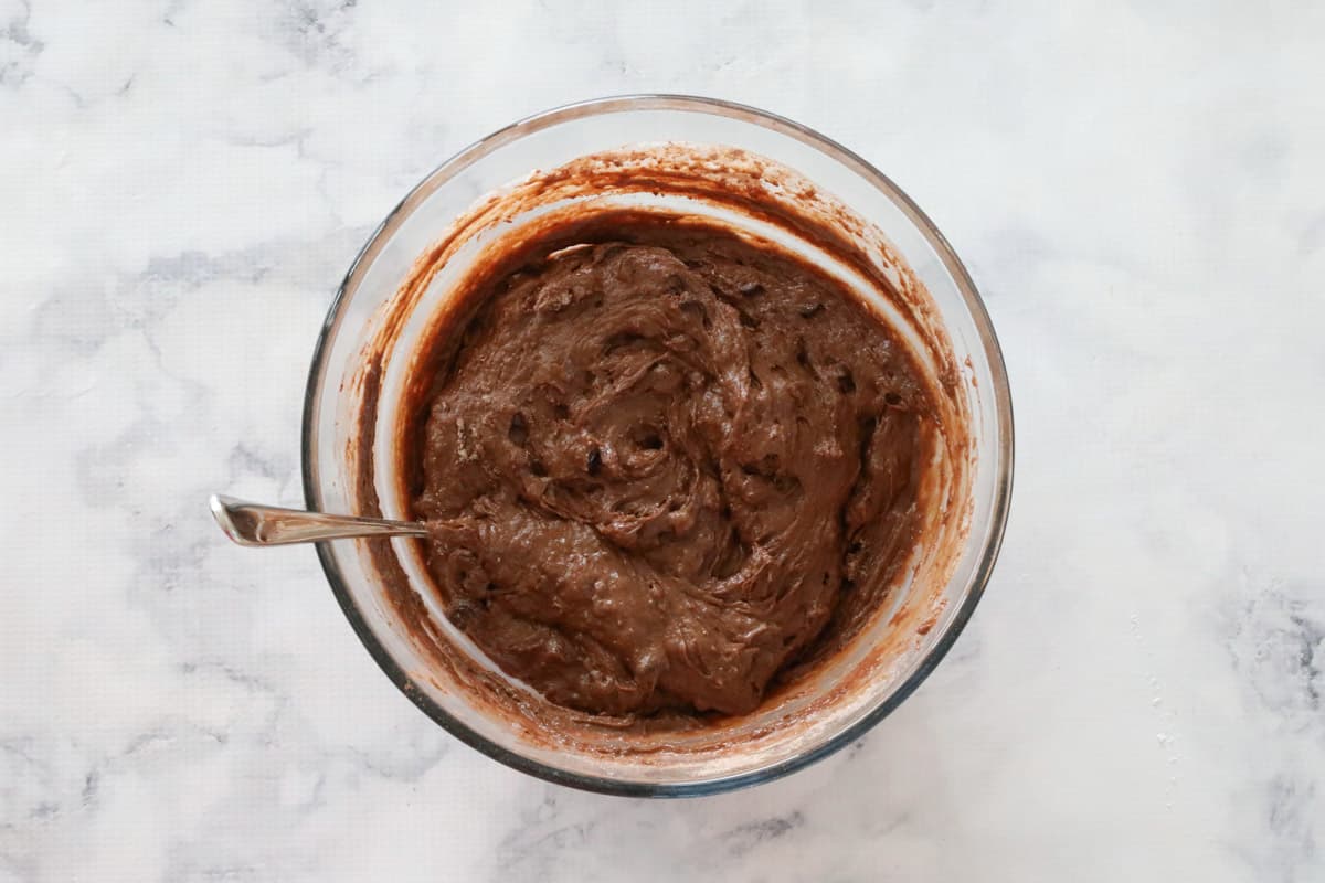 Chocolate muffin batter mixed in a glass bowl