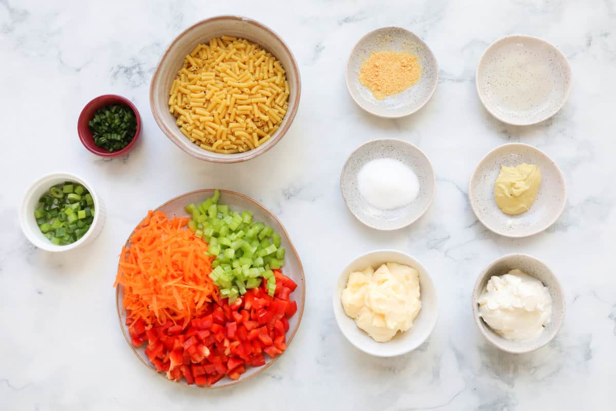 All ingredients for creamy pasta salad laid out on a table