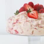 eton mess in a tall glass bowl topped with strawberries