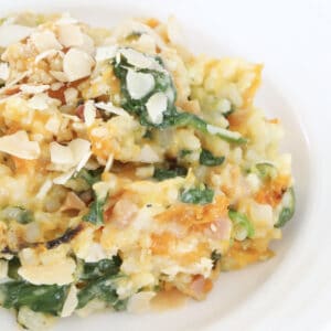 A plate of pumpkin, spinach and bacon risotto on a white plate.