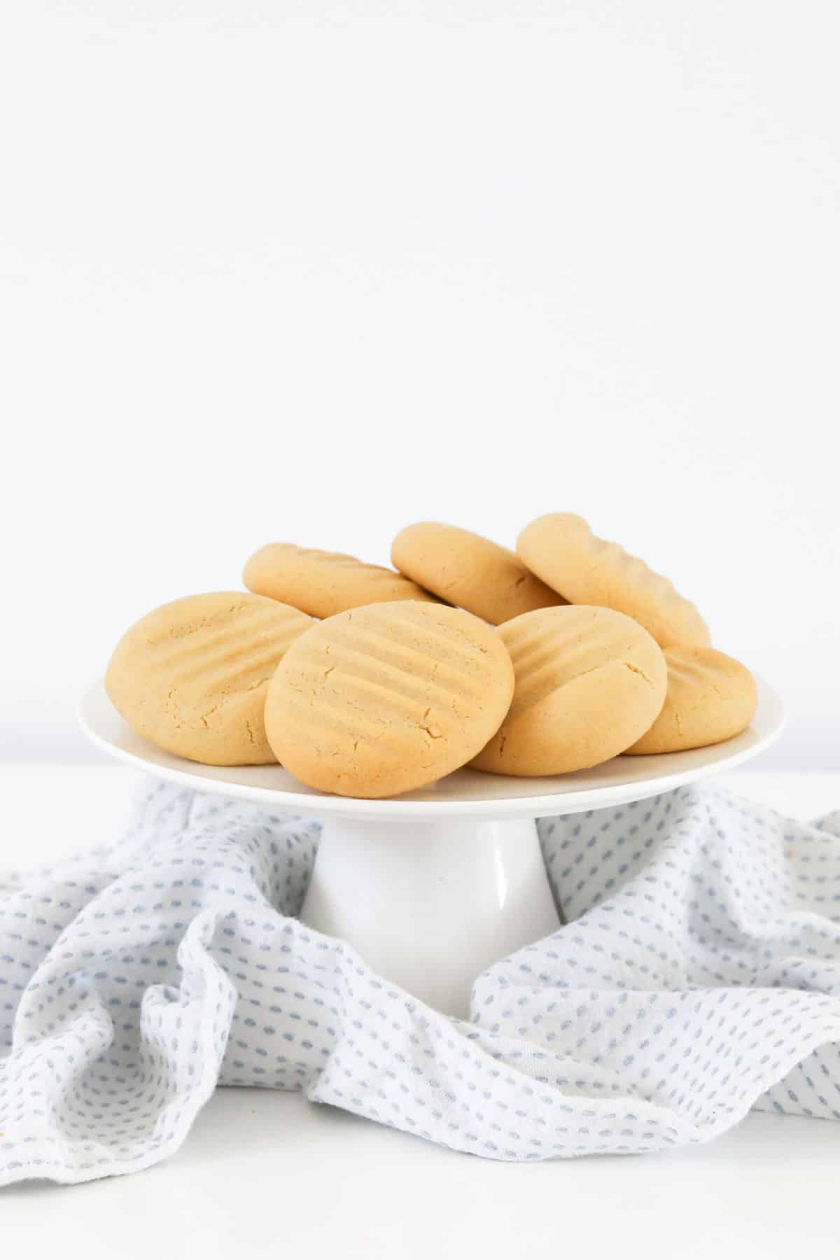 A white cake stand with a pile of Hokey Pokey biscuits served on it