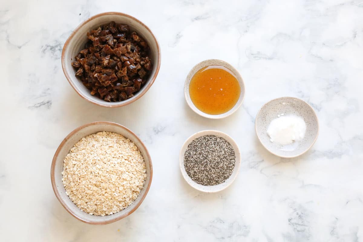 The ingredients for healthy oat & date slice in individual bowls