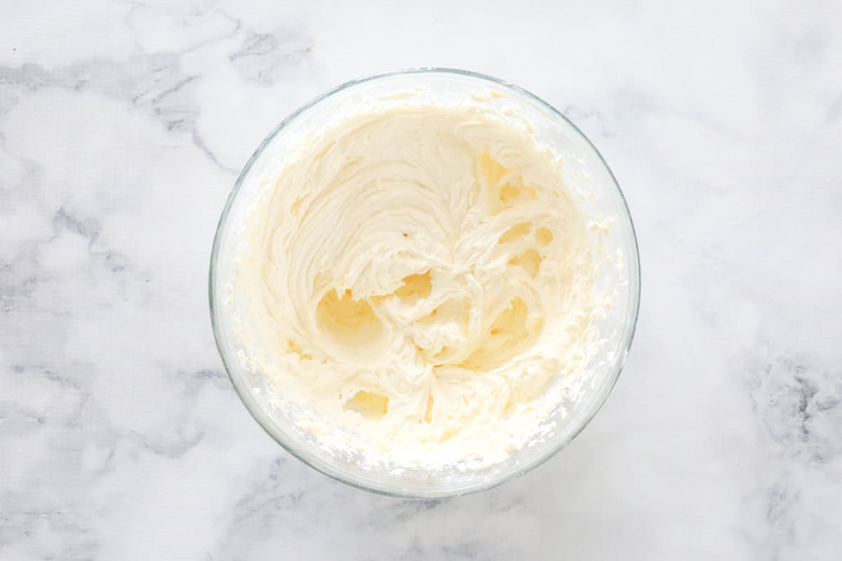 Vanilla buttercream frosting in a glass bowl