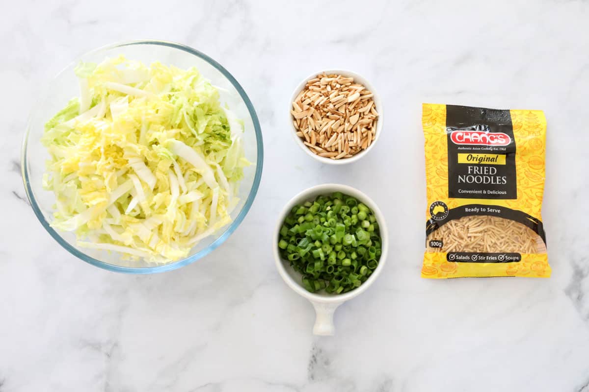 Ingredients for crispy noodle salad, laid out on a bench.