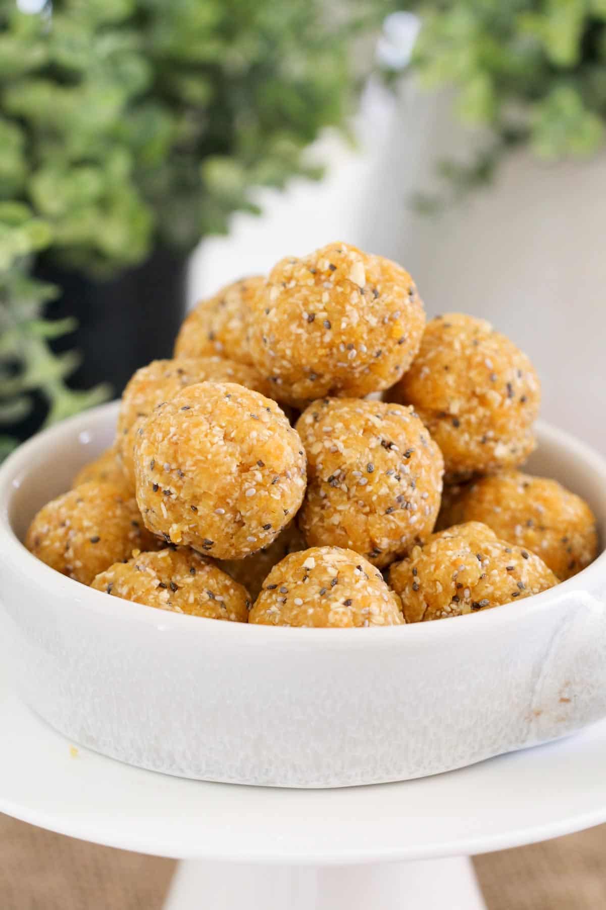 Apricot protein balls piled high in a white bowl.