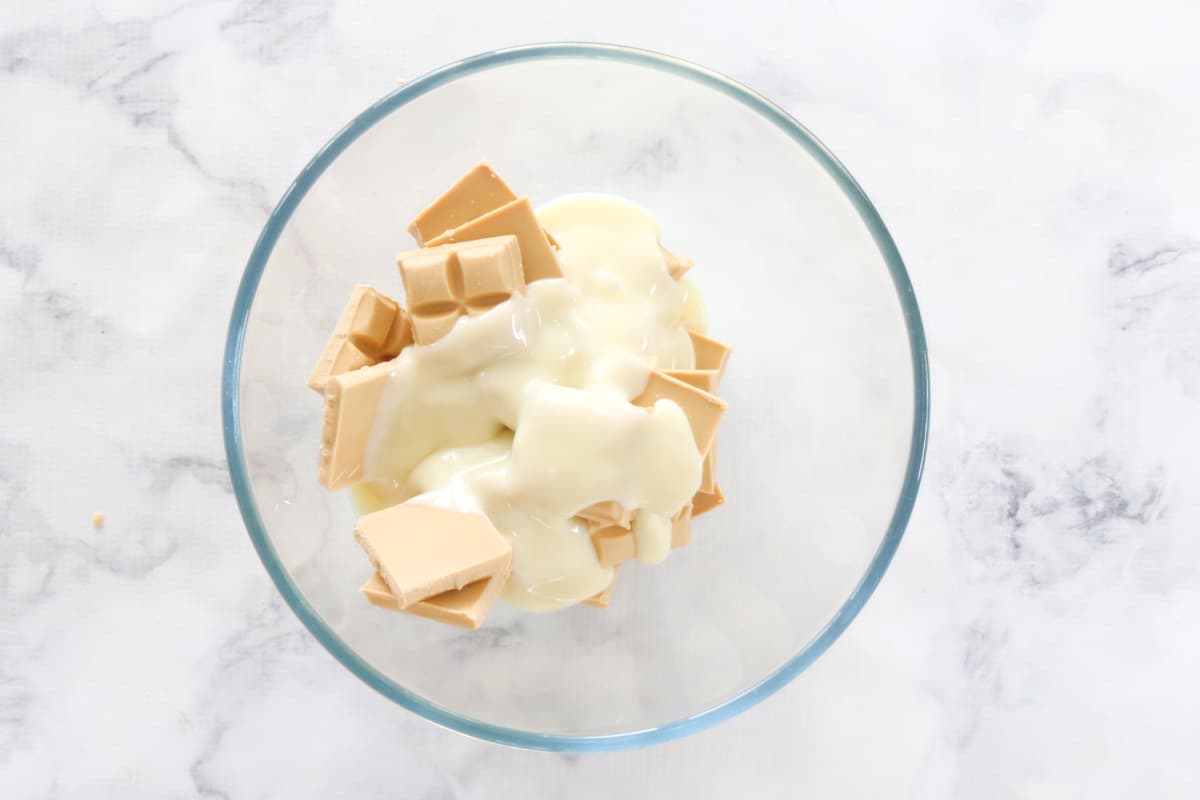 Condensed milk and caramilk chocolate in a glass bowl