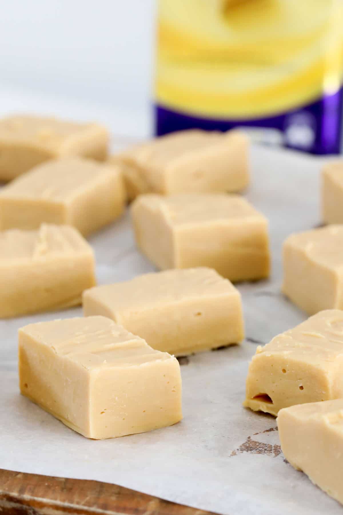 Squares of 2 ingredient fudge arranged on a tray with baking paper