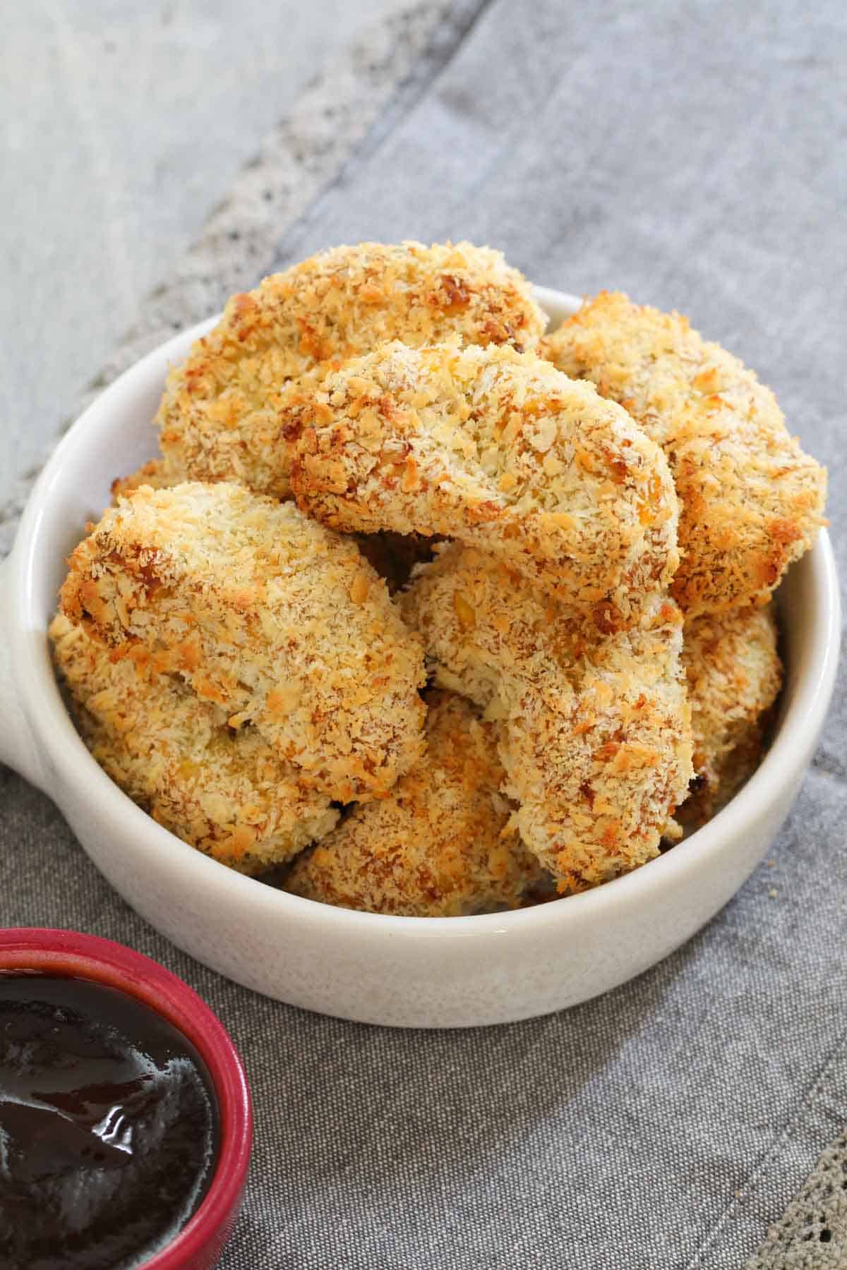 Crumbed veggie nuggets in a white bowl.