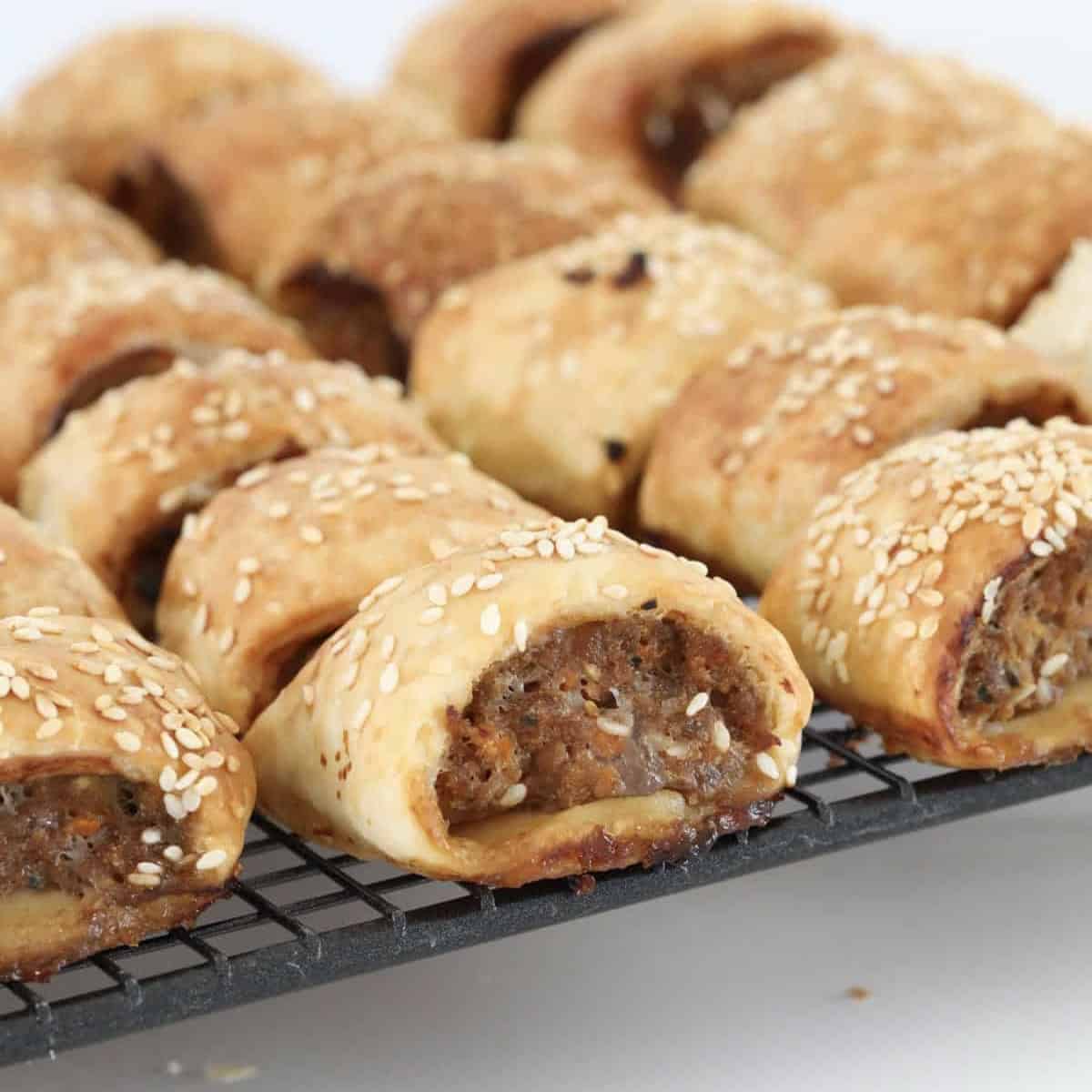 A wire rack with party sized sausage rolls.