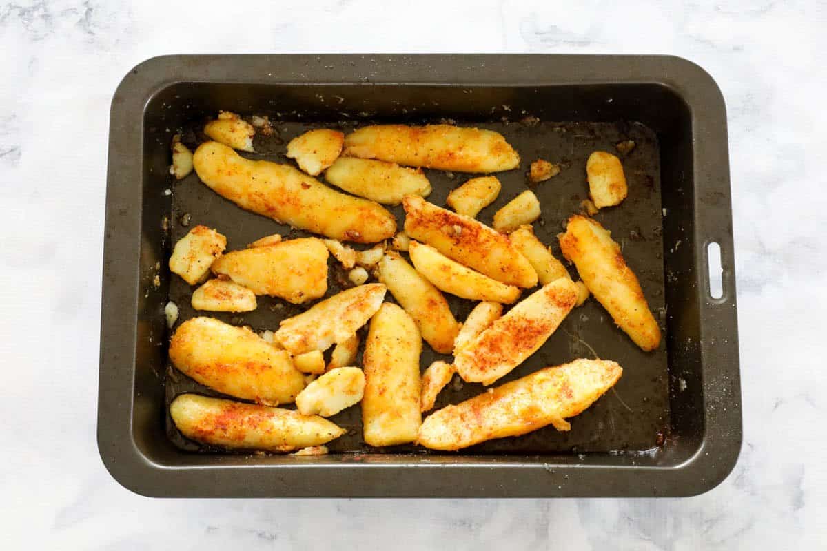 Paprika and lemon zest on golden baked potatoes cut into long chunks.