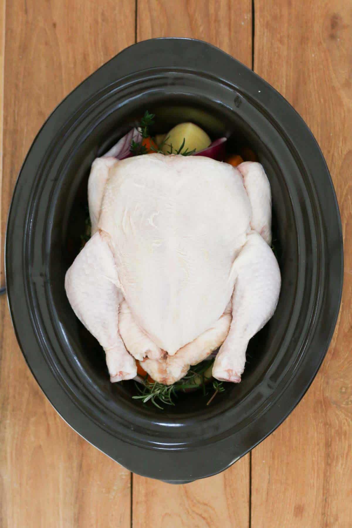 A whole chicken in a slow cooker.