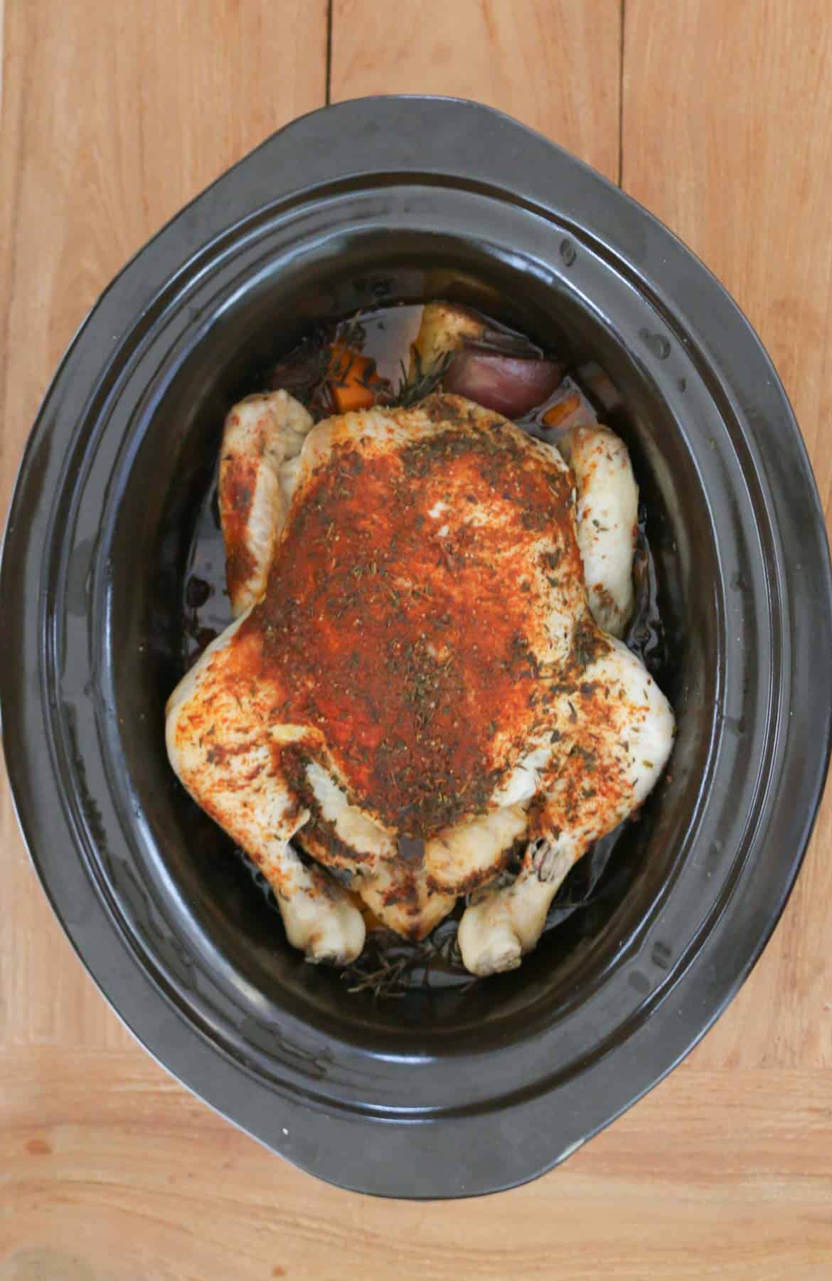 A whole cooked roast chicken in a crock pot.