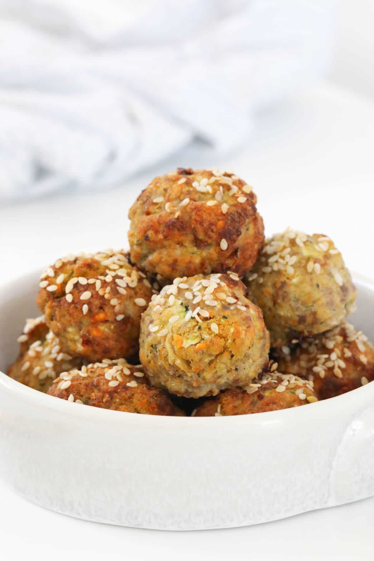 Healthy turkey and vegetable meatballs in a white serving dish