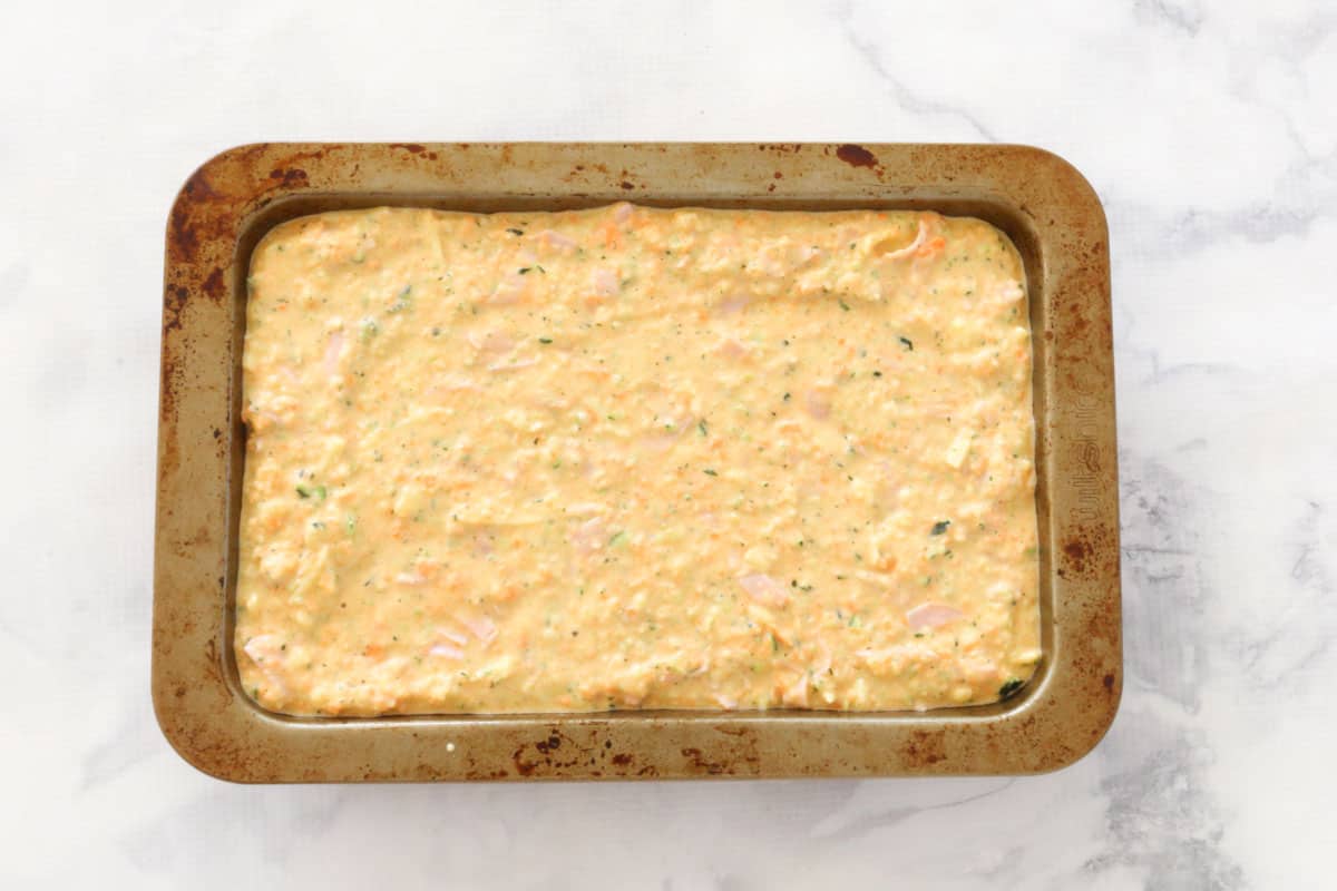 Uncooked mixture poured into a rectangular baking tin.