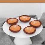 5 mini tarts filled with caramel and served on a white cake stand