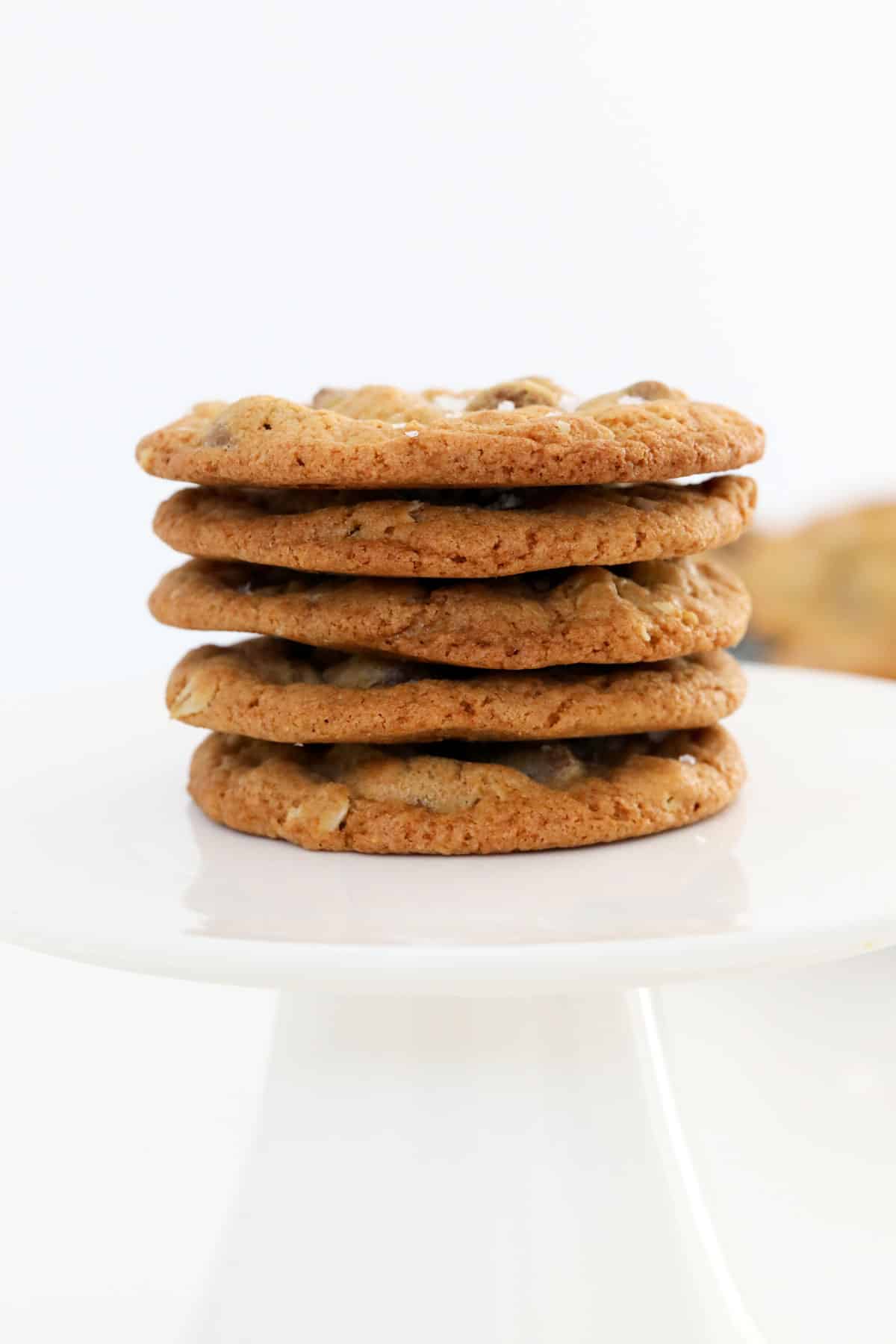 A stack of oatmeal cookies on a white stand.