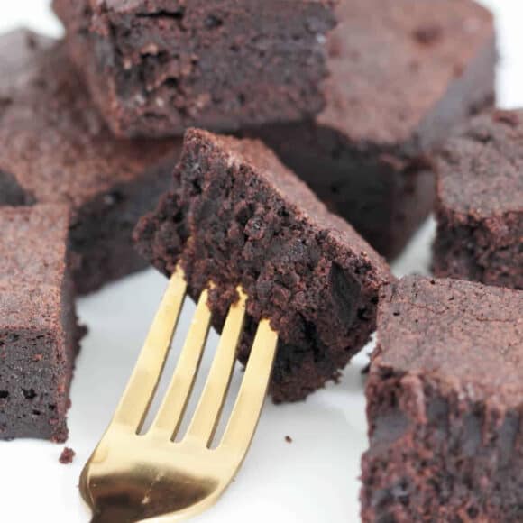 A half eaten fudgy chocolate brownie on a gold fork.