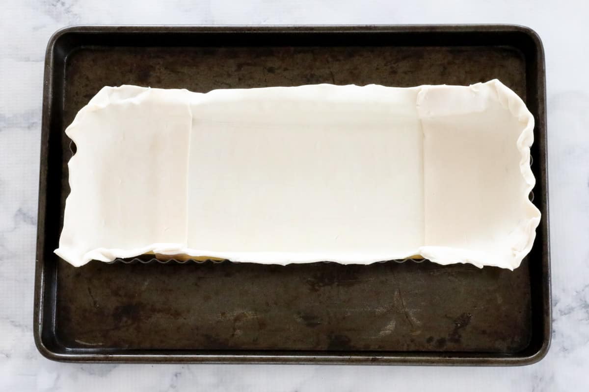 Uncooked puff pastry in a rectangular pie tin.