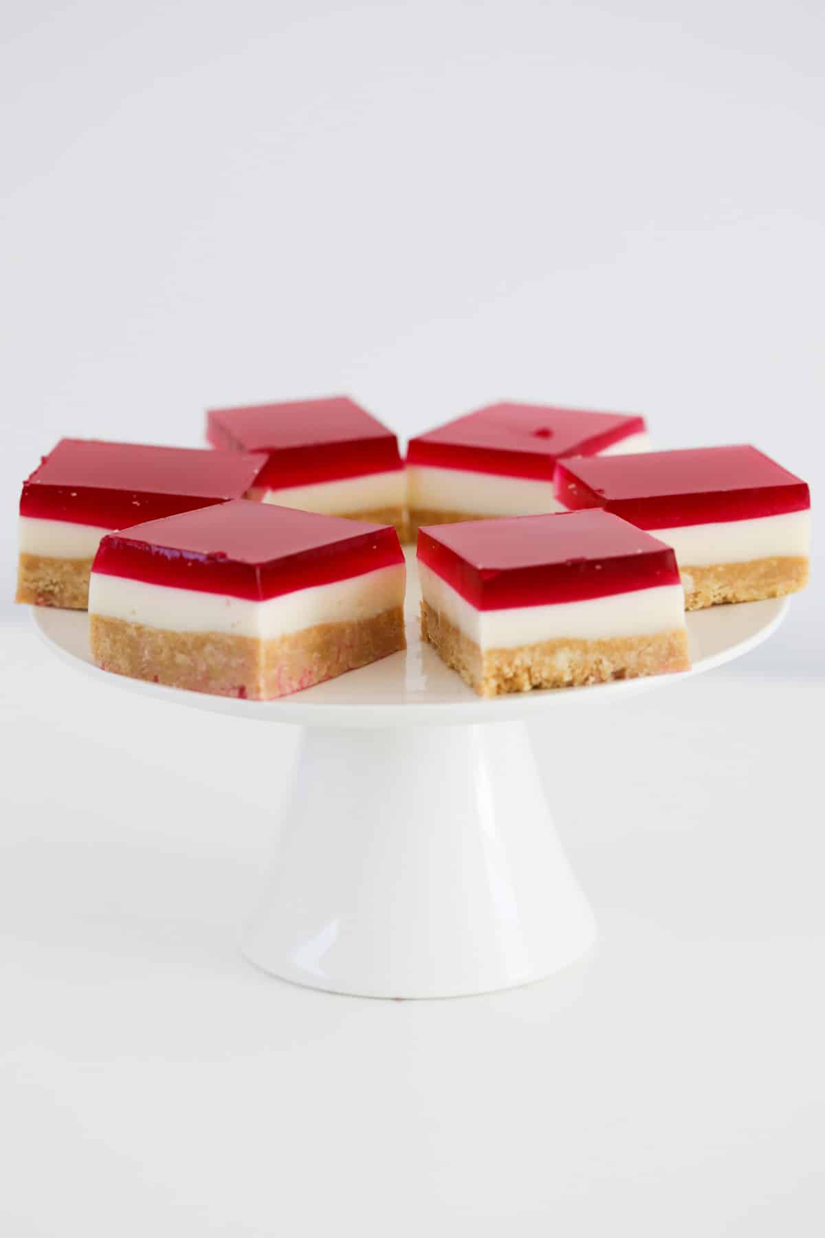 A cake stand topped with triple layered slice.