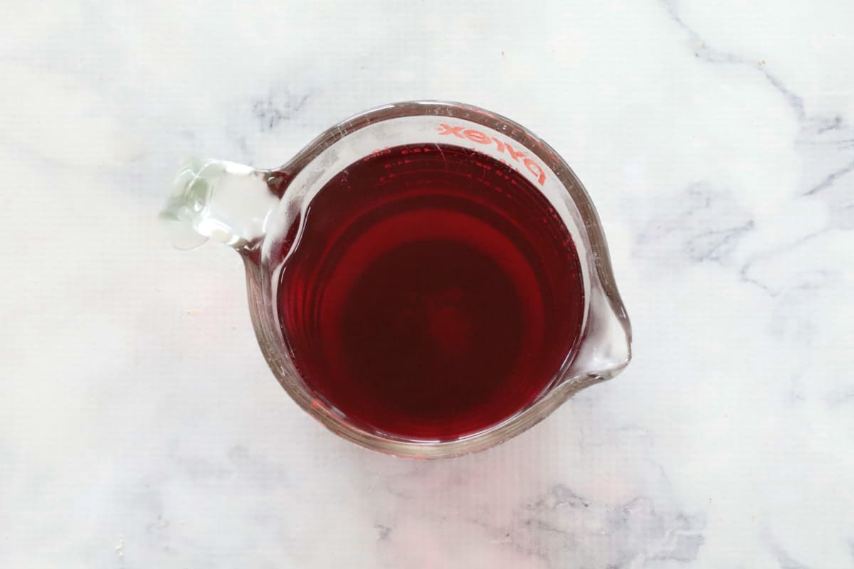 Raspberry jelly in a glass jug.