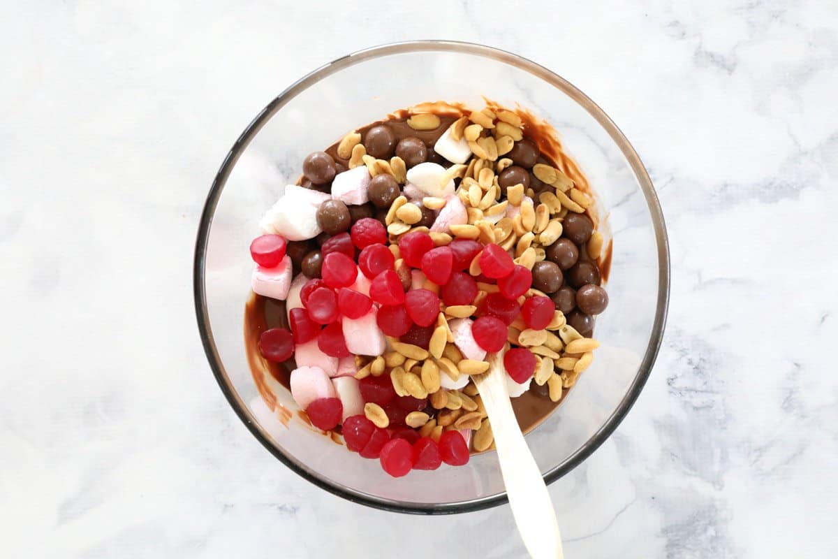 Raspberry lollies, peanuts, marshmallows and Maltesers in a bowl.
