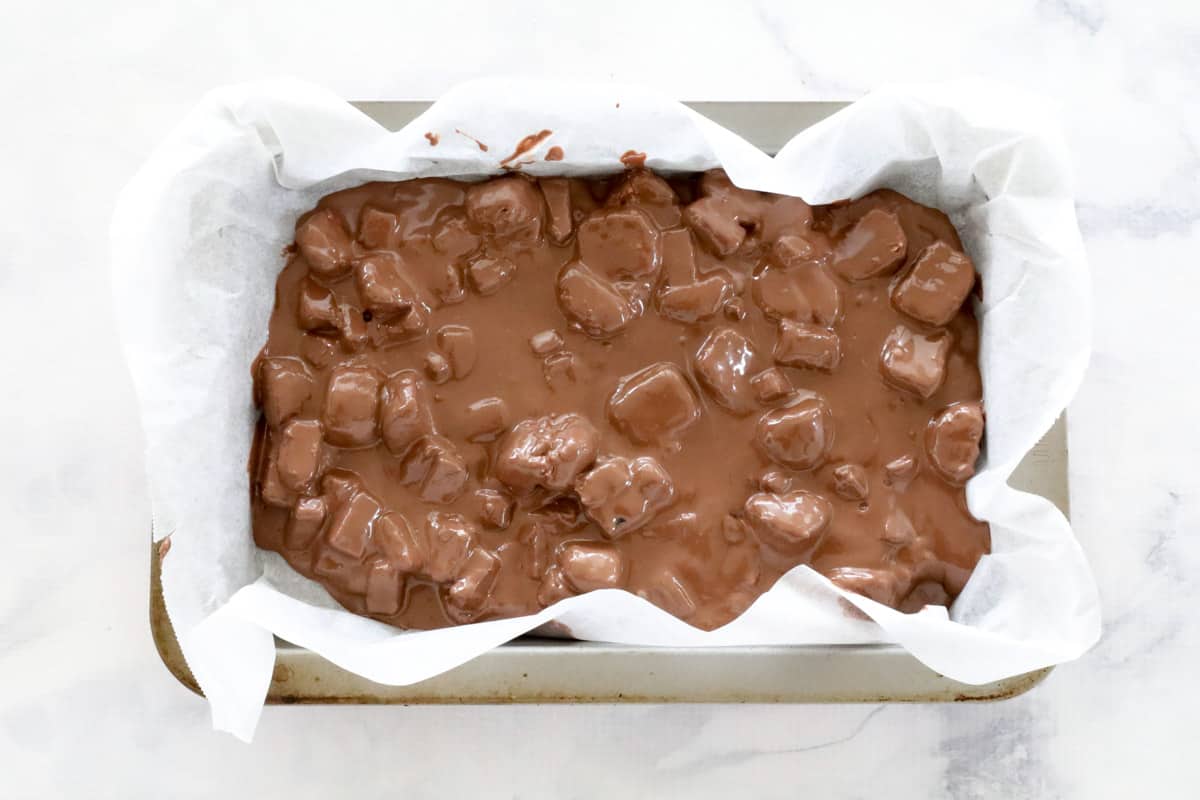 A baking paper lined slice tin filled with Rocky Road
