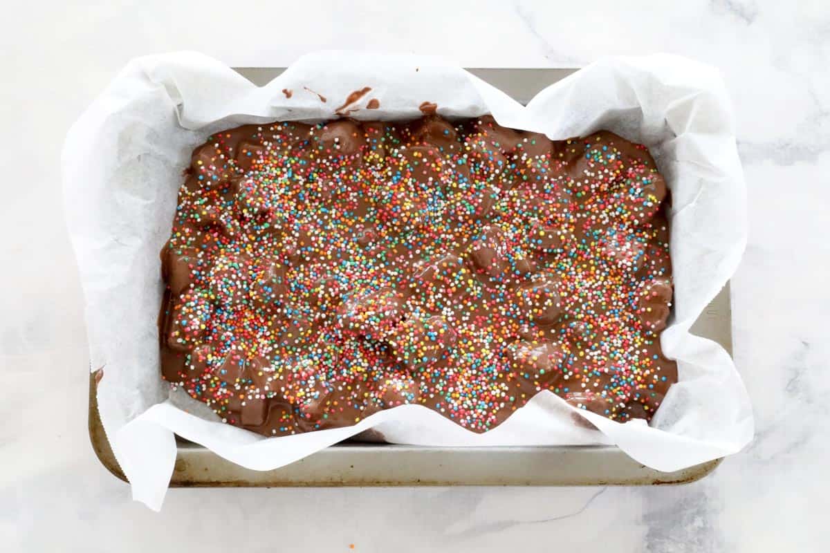 Rainbow sprinkles covering Easy Rocky Road in a lined slice tin