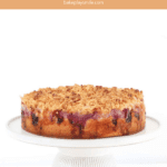 Raspberry and apple layers over a butter cake base, and topped with a crunchy crumble, served on a cake stand